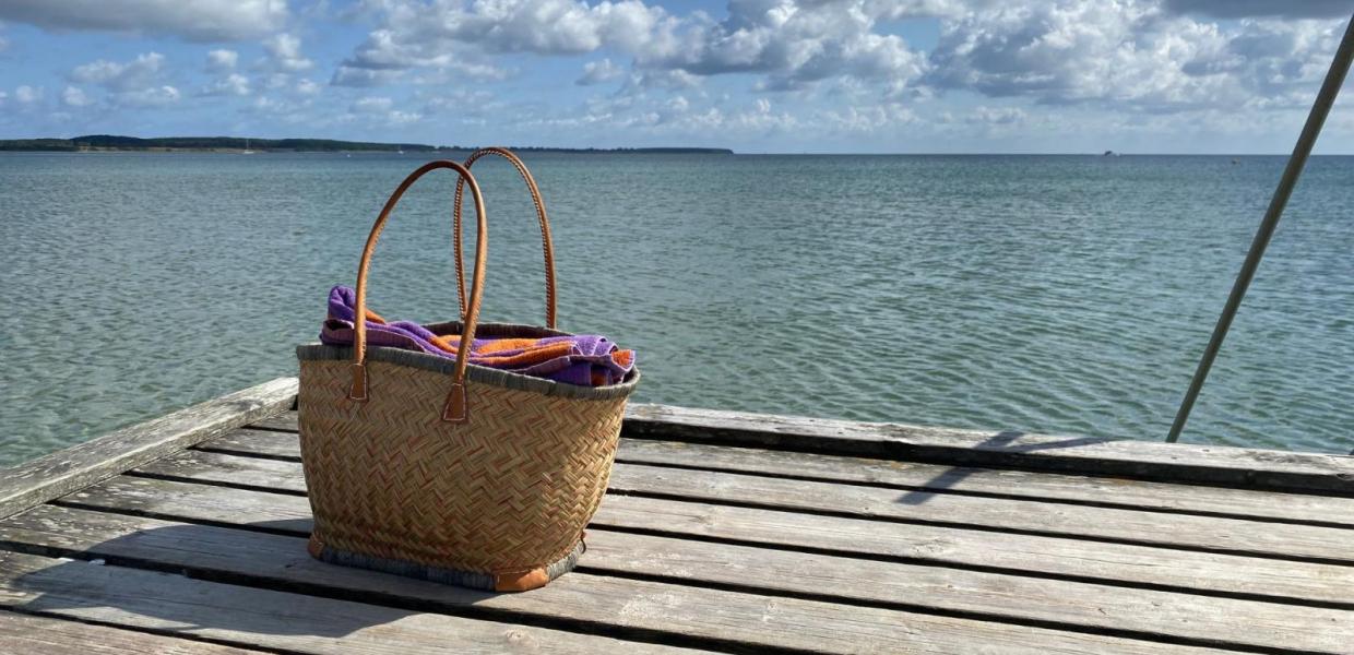 Strandtaske på Sydstrandens badebro i Kerteminde med havet og himlen i baggrunden. 